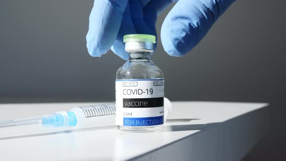 COVID19 Vaccine in Researcher Hands Doctor Takes Ampoule in Hand and Syringe with Vaccine for