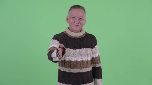 Happy Mature Japanese Man Giving Handshake Ready for Winter