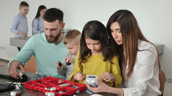 Family with Children in a Robotics Club Makes a Robot Controlled From a Constructor