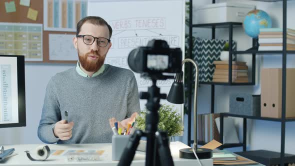 English Tutor Explaining Grammar Pointing at Computer Screen and Recording Lesson with Camera for alt