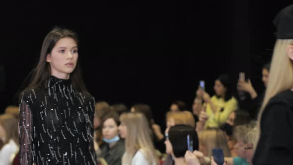 Several Female Models Walking in Row on Fashionable Luxury Vogue Show Runway