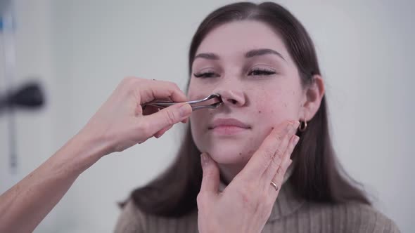 Professional Female Doctor Otorhinolaryngologist Doing Nose Examination with Otoscope in Modern