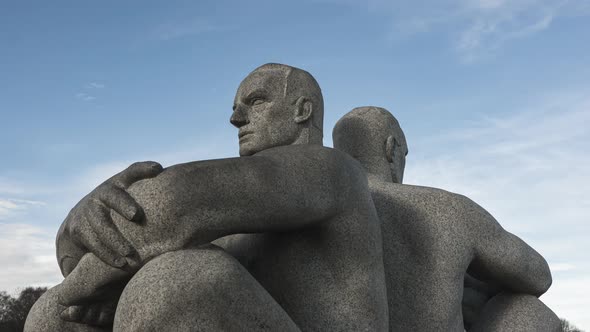 Granite Sculpture Of Two Men Sitting Back to Back With Crossed Arms At Vigeland Installation In Frog