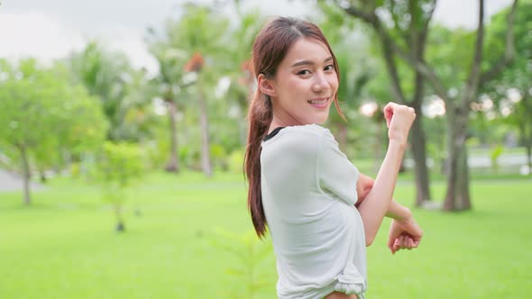 Portrait of Asian active sport woman stand with confidence after exercise outdoors at public park.