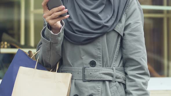 Happy Muslim Woman Carrying Bags With Purchases, Calling Taxi After Shopping