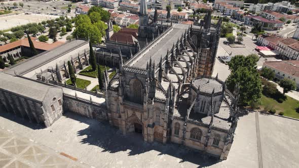 Masterpiece building with towers of Batalha Monastery in Portugal, aerial orbit view