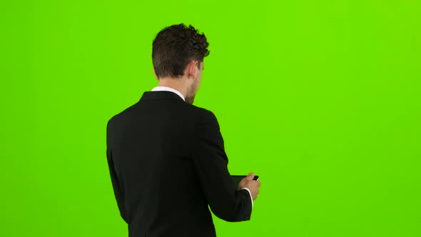 Businessman Is Going To Work and Prints Important Messages. Green Screen. Back View