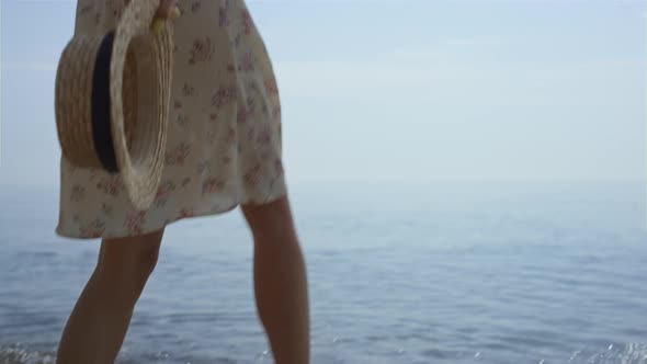 Barefoot Woman Splashing Ocean Water By Legs Close Up