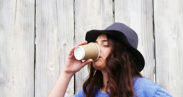 Beautiful woman in hat having coffee