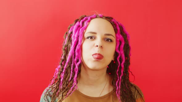 Young Female with Dreadlocks Looking at Camera and Showing Tongue