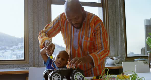 Father and son repairing toy car in a comfortable home 4k