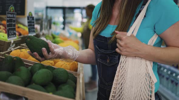 Happy woman buying fresh fruits inside supermarket