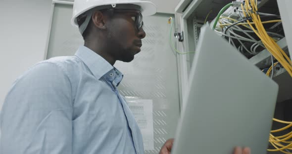 Man Using a Laptop While Working in a Server Room