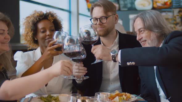 Diverse Business Partners Clinking Glasses Celebrating Agreement in Restaurant