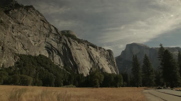 Slow Pan Right Across Grassland With View Of Granite Cliffs At Yosemite