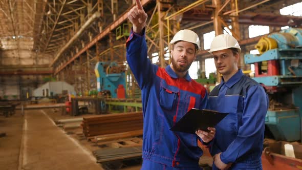 Two Workers Discuss a Construction Project