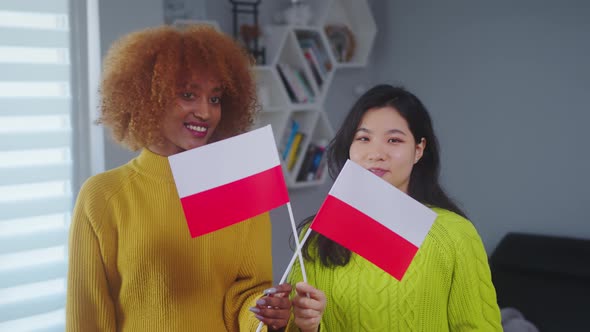 Multiracial Friendship and Equality. African American and Asian Woman Holding Polish Flag. Student