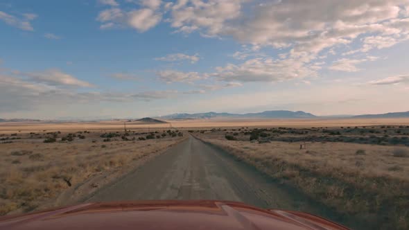 Point of view driving on dirt road through the open country in the Utah desert