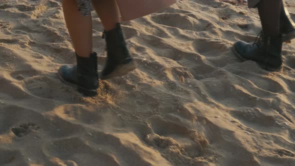 Closeup Cinematic Shot of Woman Feet in Boots Walking on the Beach at Sunset or Sunrise