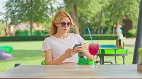 Young Woman Enjoys Talking on the Phone Texting with Someone in a Wonderful Place Sitting in a White