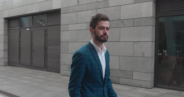 Caucasian Businessman in a Suit and with Dark Glasses Walking on a Street in Downtown