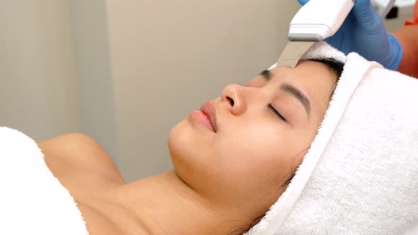 Beauty Specialist Makes Ultrasonic Peeling for Female Client's Face