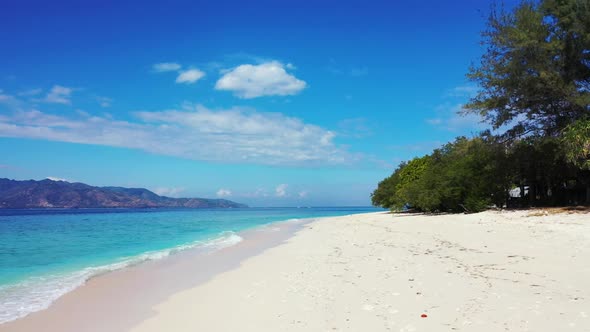 Aerial above nature of idyllic shore beach break by aqua blue lagoon with white sandy background of 