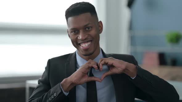 Portrait of African Businessman showing Heart Shape by Hands