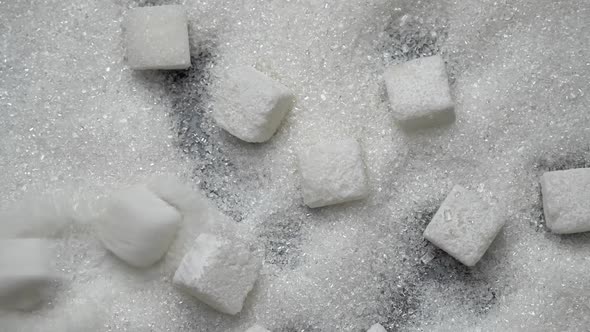 White Sugar Cubes Fall on Granulated Sugar