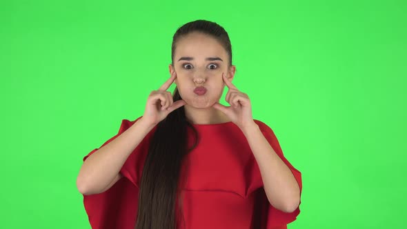 Portrait of Pretty Young Woman Is Posing for Camera and Making Funny Faces . Green Screen