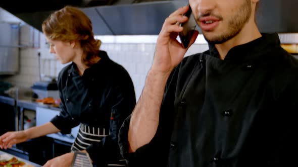 Chef looking at clipboard while talking on mobile phone 4k