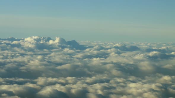 Airplane Window View on Dense and Billowing White Clouds