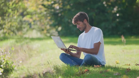 Freelance Working at a Laptop While Sitting Near Camping Typing Text and Remote Work in Nature Man