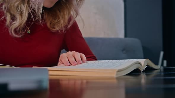 A Young Sad Female Student Overwhelmed with Homework Sits with a Laptop in a Cafe alt
