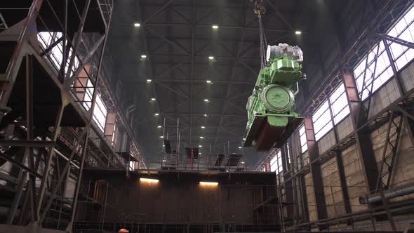 Huge Engine Hangs on Hook Near Restored Fishing Ship in Dock