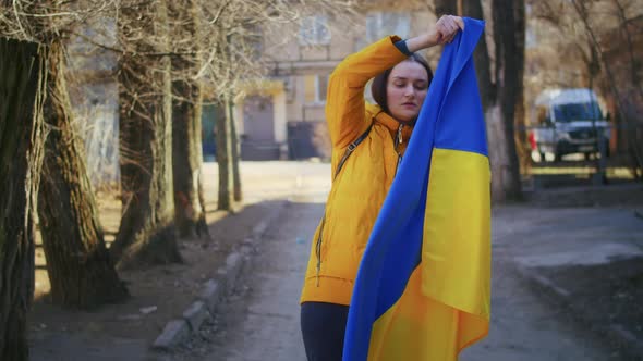 Portrait of a Sad Ukrainian Woman with a Ukrainian Flag and a Sign