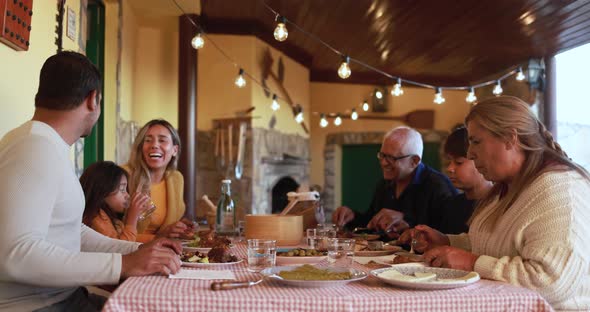 Happy latin family eating dinner at vintage restaurant terrace