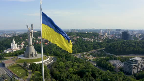 Aerial View of the Ukrainian Flag Waving in the Wind Against the City of Kyiv