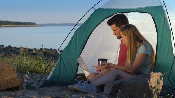 Relaxed Couple of Travelers Camping at Seaside