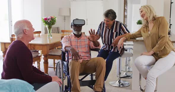 Two diverse senior couples sitting on a couch disabled african american man is using vr googles