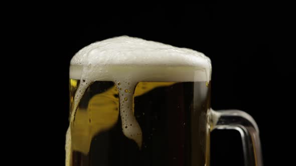 Pouring Cold Golden Light Beer Into a Glass. Craft Beer Making Bubbles and Foam