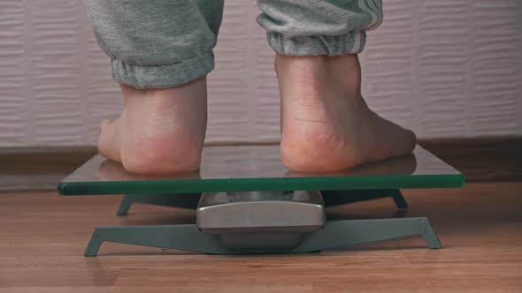 Women's Feet Stand on the Scales and Check Their Kilograms Back View