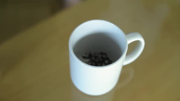 The girl pours tea leaves into a mug and pour boiling water. Brewing tea