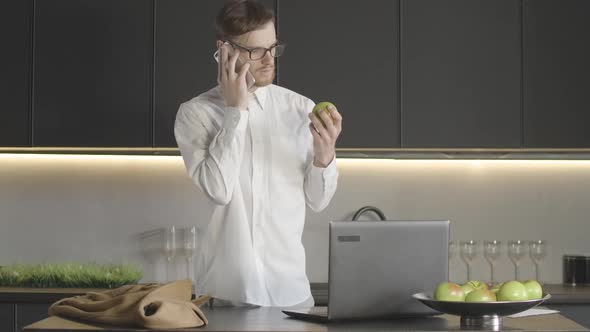 Busy Caucasian Businessman Closing Laptop, Taking Coat and Leaving the Kitchen. Young Successful