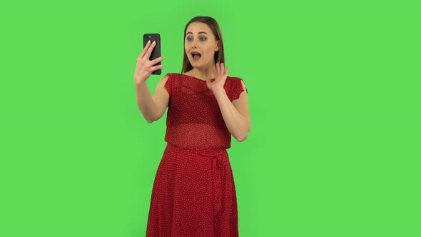 Tender Girl in Red Dress Is Talking for Video Chat Using Mobile Phone and Dissatisfied. Green Screen