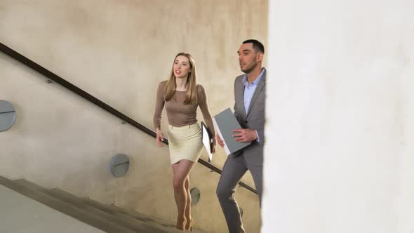 Businesswoman and Businessman Walking Upstairs