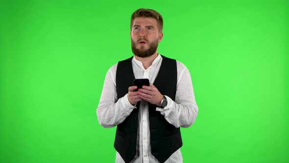 Tired Man Texting on His Phone on Green Screen.