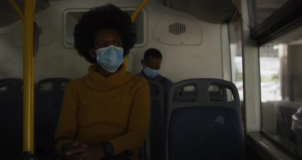 African american businesswoman with face mask sitting in bus