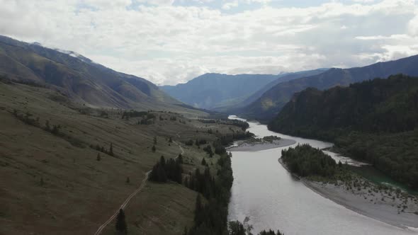 River Katun between mountains of Ak-Kem valley under white clouds in Altai