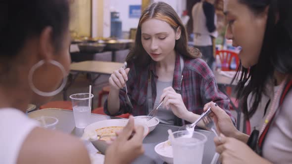 A group of multi-ethnic female friends enjoying street food on Yaowarat Road or Chinatown in Bangkok